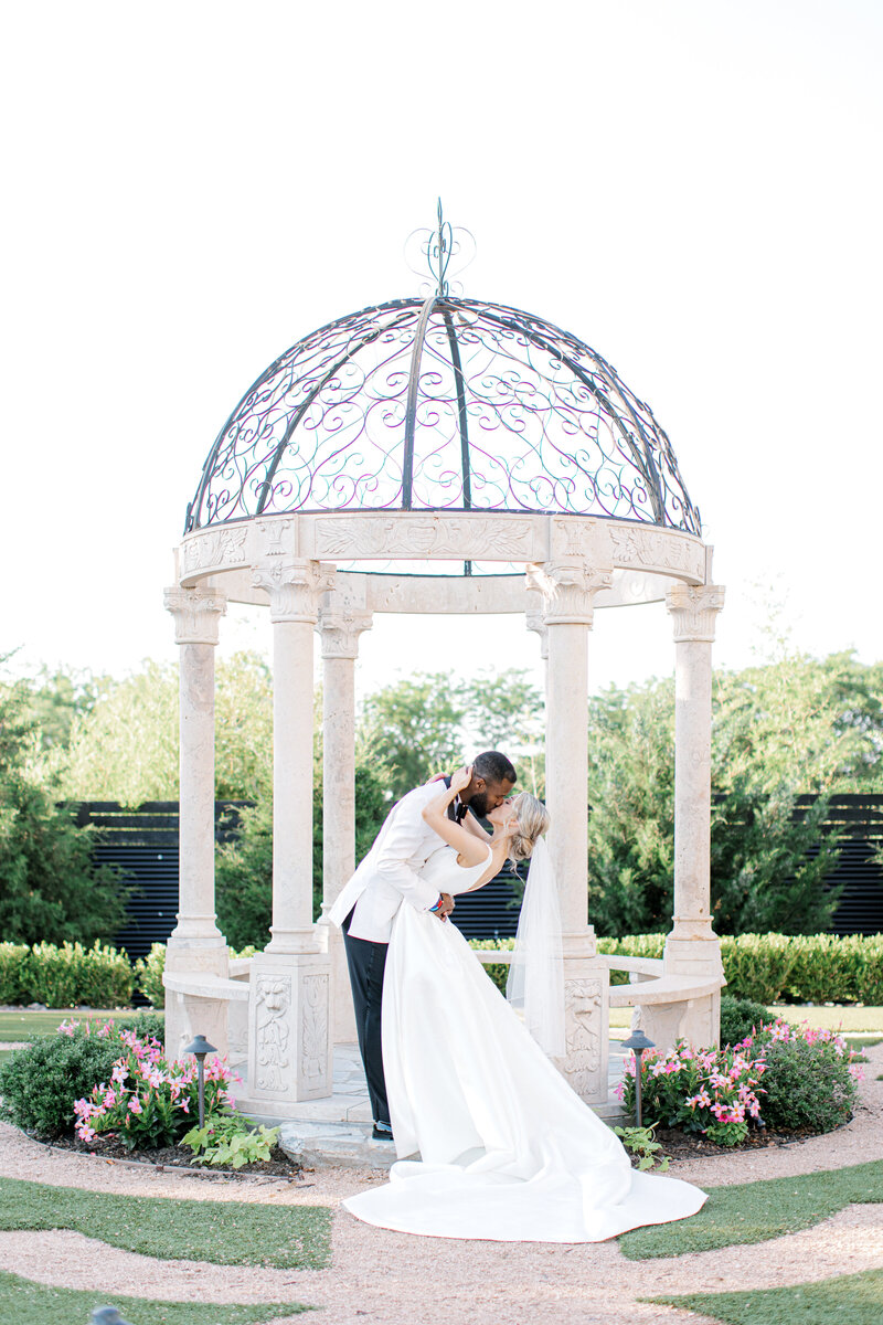Swank Soiree Dallas Wedding Planner Kelci and CJ Knotting Hill Place - Bride and Groom kissing in a gazebo