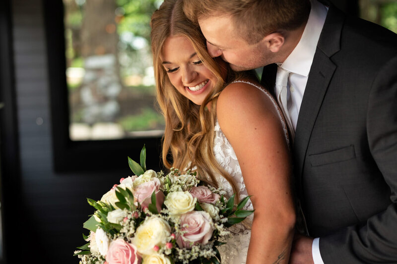 Bride and groom snuggle on their wedding day.