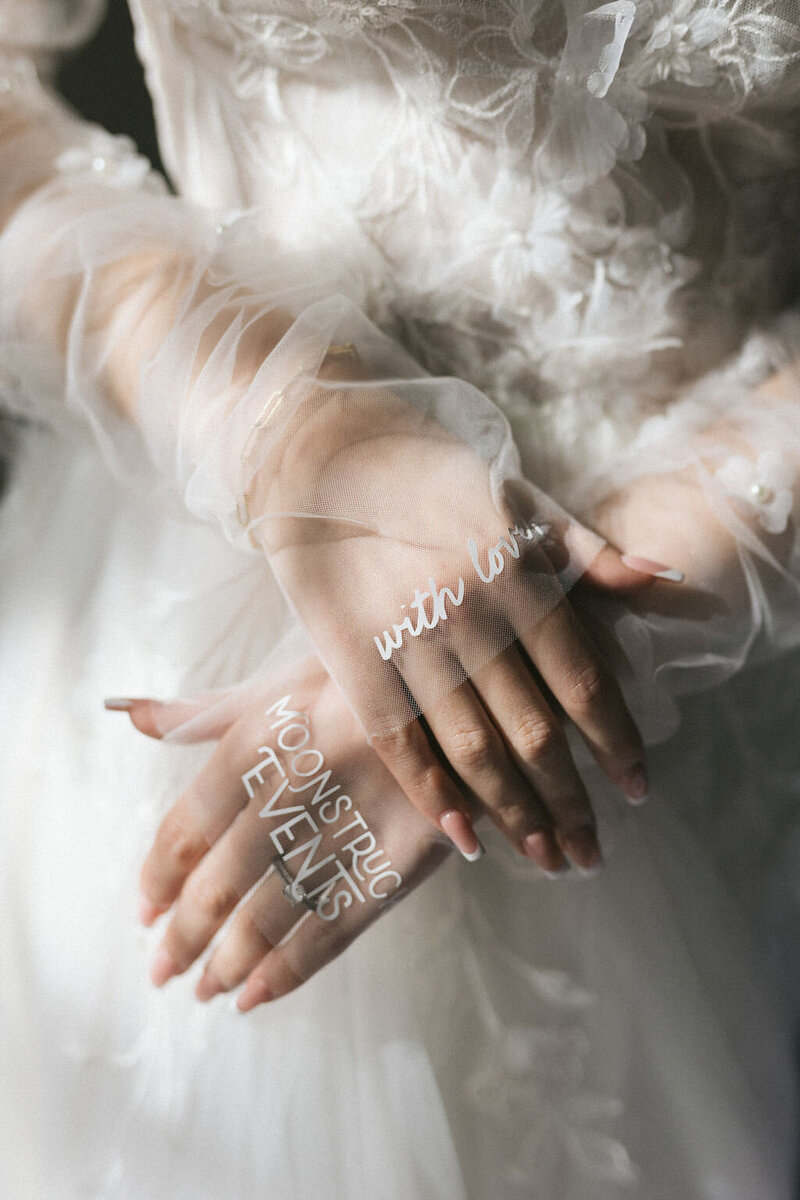 Boho wedding couple holding hands in the desert. Bride and groom wearing luxury wedding dress and tux.