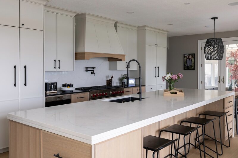 Modern kitchen with off white cabinets and sleek black fixtures.