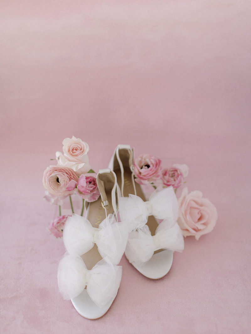 Light pink suede mat with blush-toned invitations and florals