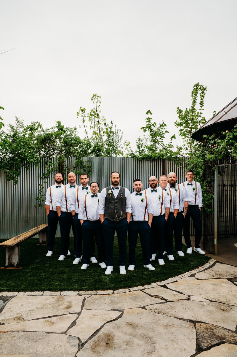 Groom and groomsmen standing in a flying v