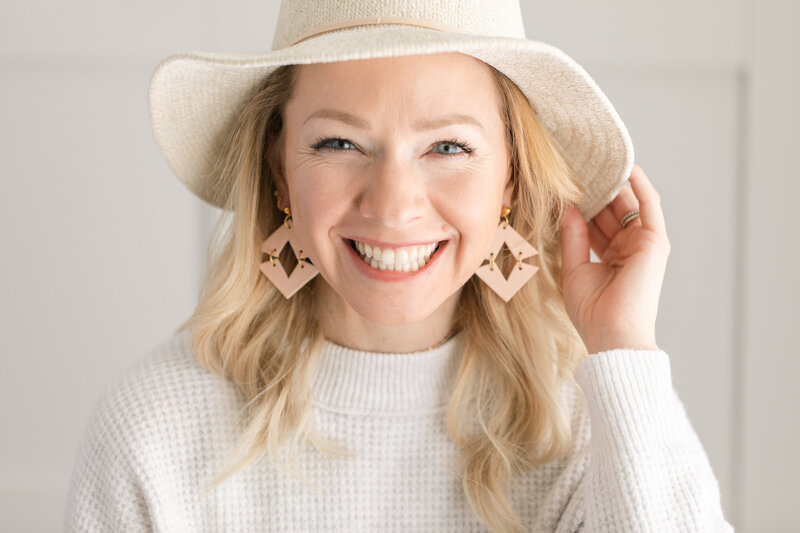 lady wearing earrings and hat for brand shoot