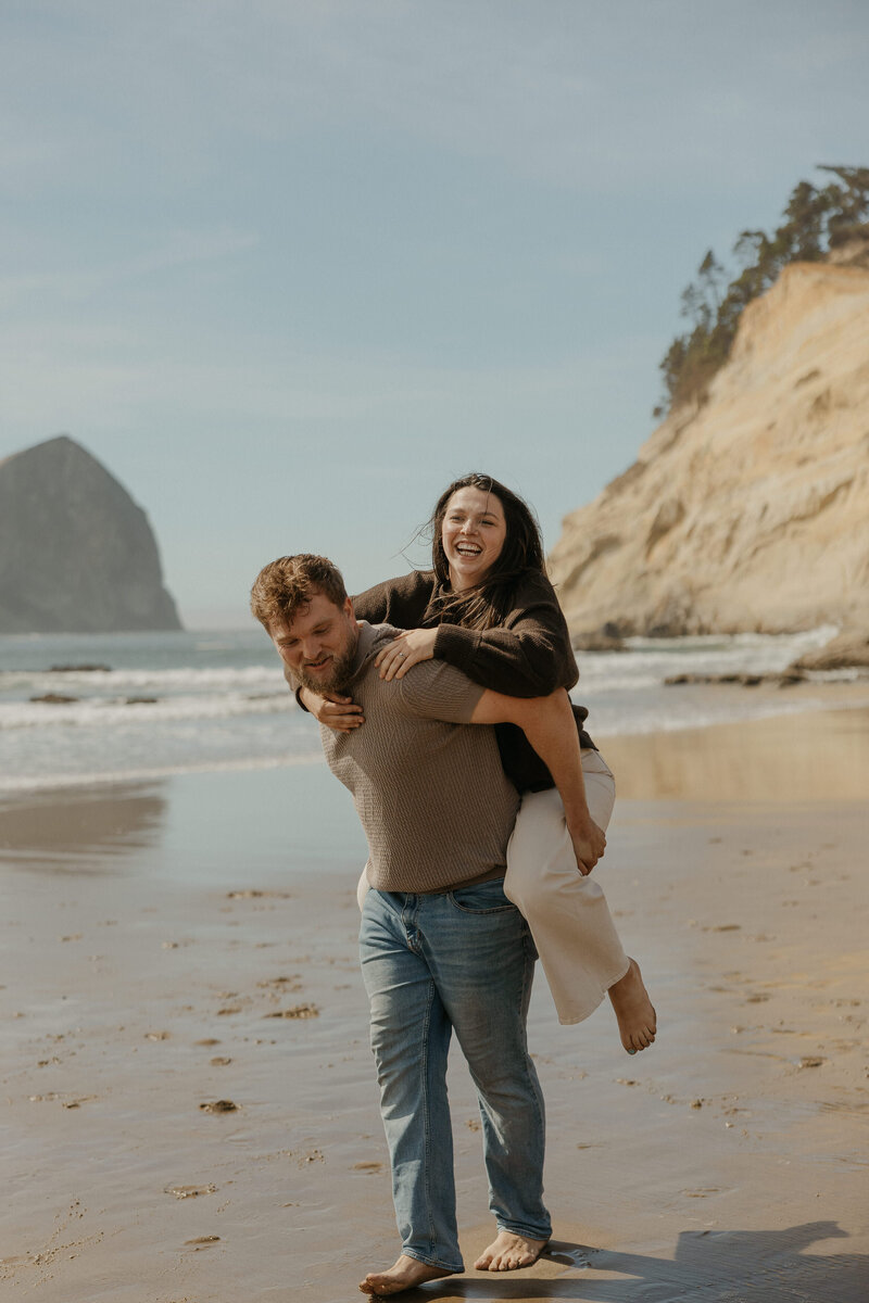 A person laughing as they hang onto their partner's back 