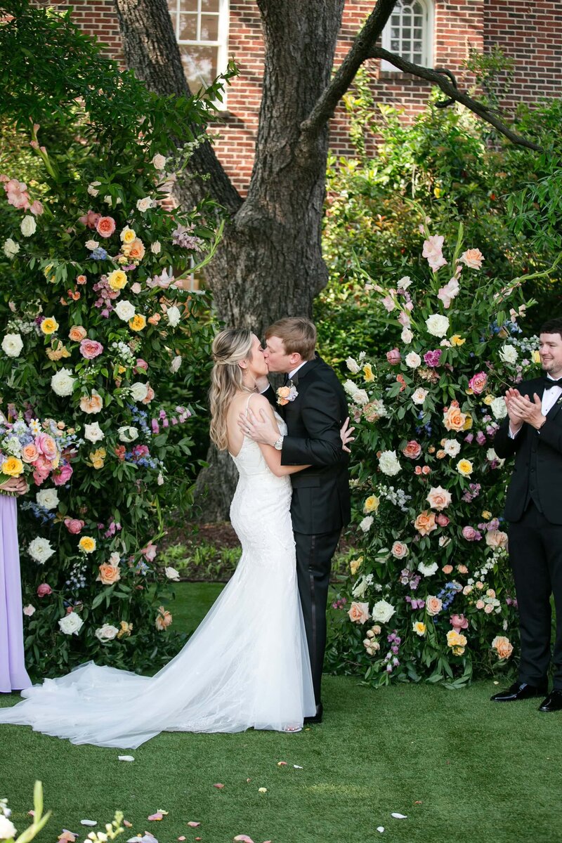 first kiss as husband and wife at the end of outdoor ceremony at Merrimon-Wynne