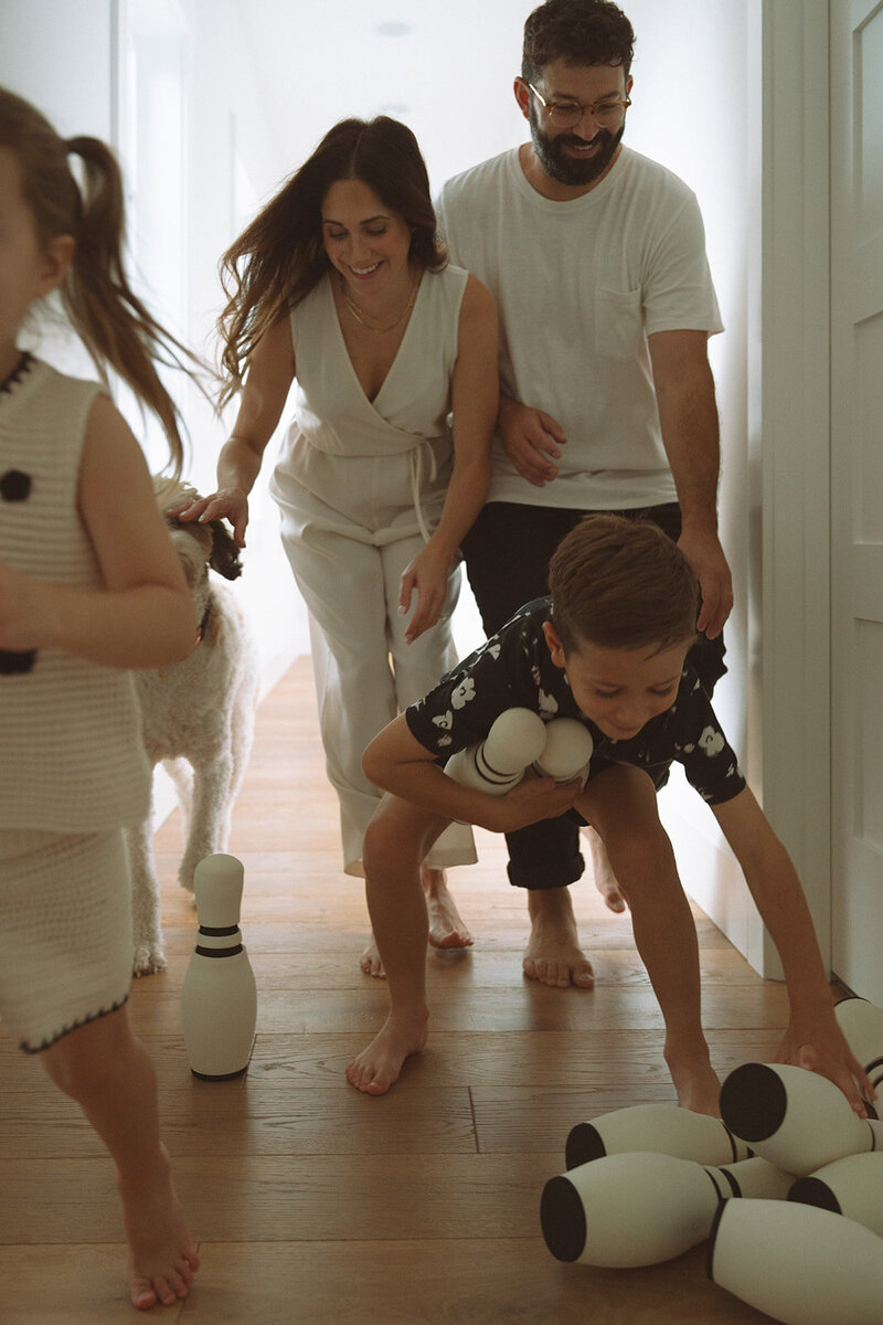 family playing with bowling pins at. home