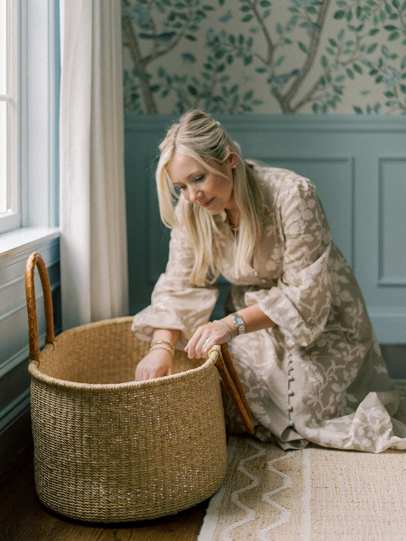 Mom peering into a bassinet with baby inside