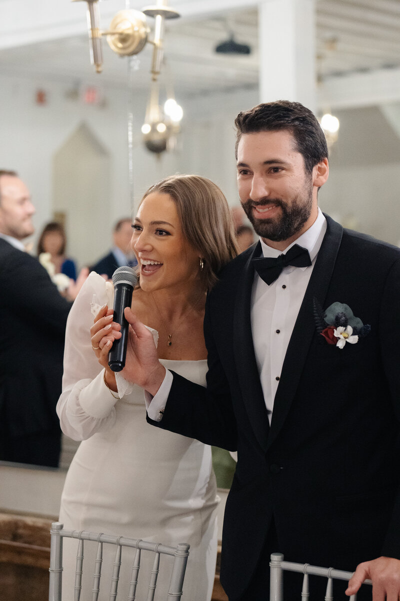 Bride and groom joyfully give a speech at their wedding reception