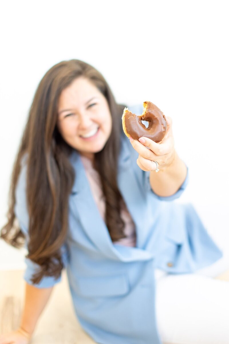 Taylor holding up a donut she took a bit out of