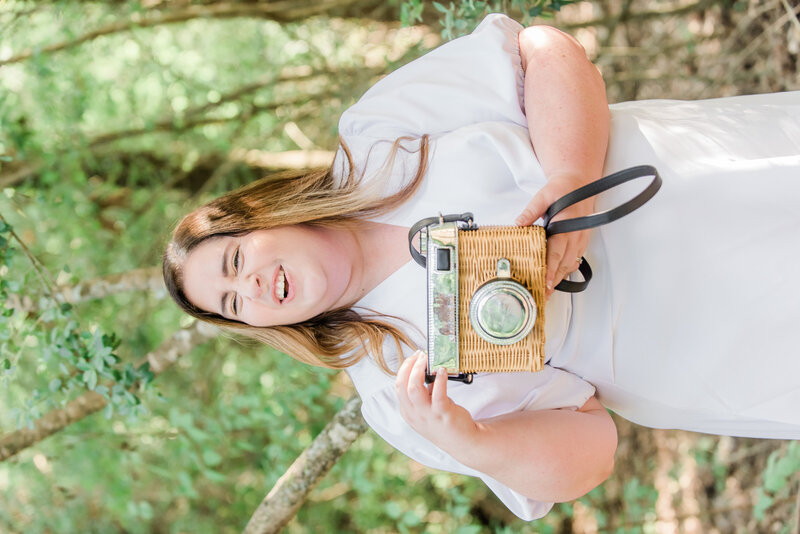 Swish and Click Houston wedding photographer holds ups her camera purse and laughs