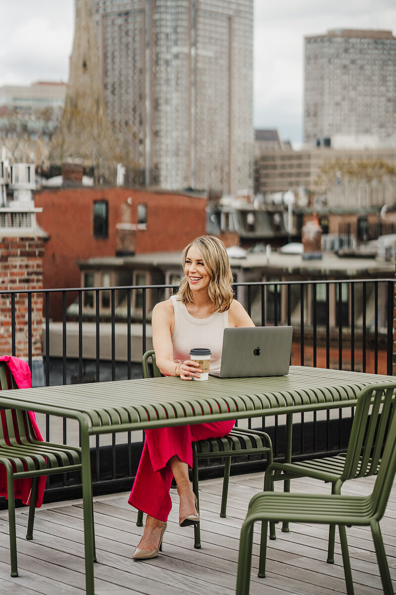 women works on rooftop deck for brand photoshoot
