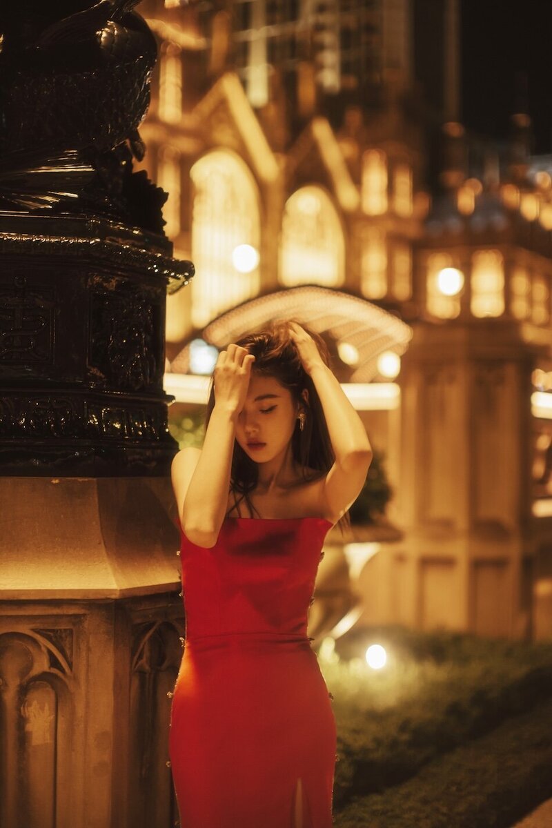 Destination couture photoshoot with a woman in. a red gown at night in the city.