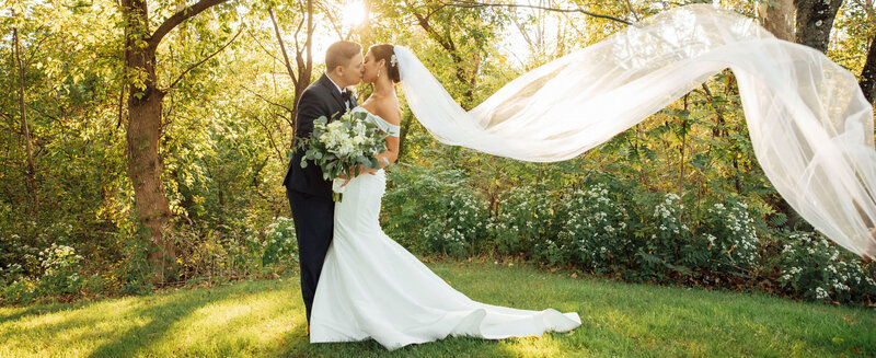 Bride and groom kissing at sunset with flowing veil | Summer Wedding at The Hamilton Manor | Hamilton Township, New Jersey