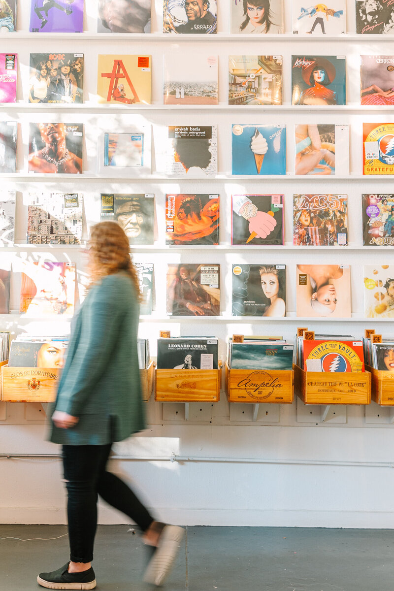 Allison Bolin Texas wedding photographer walking in front of a record wall