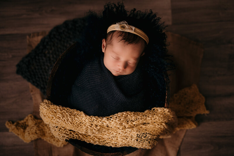 Newborn baby girl in wool onsie and floral headband