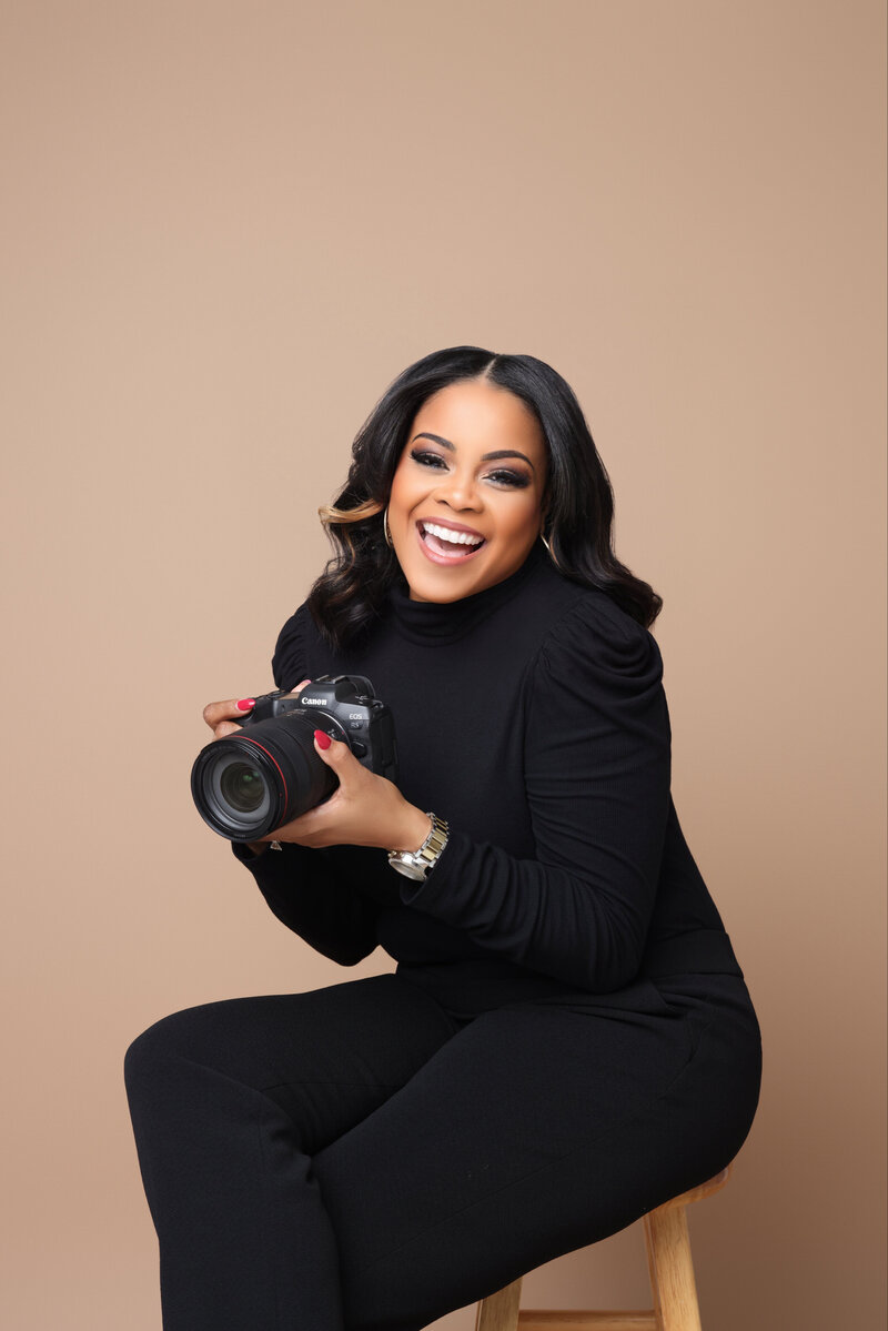 Angela smiling while holding a camera