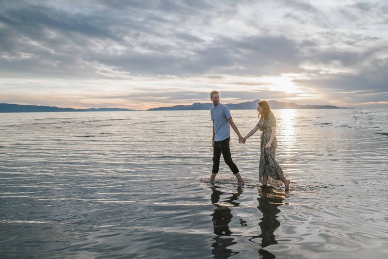 Big Sur wedding photographer captures beach engagements while couple walks hand in hand