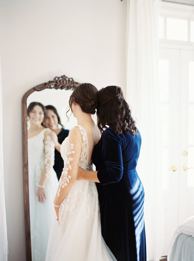 Bride and her mother sharing a heartfelt moment while looking in the mirror on the wedding day, captured on film by Morgan Alysse, Louisiana film photographer.