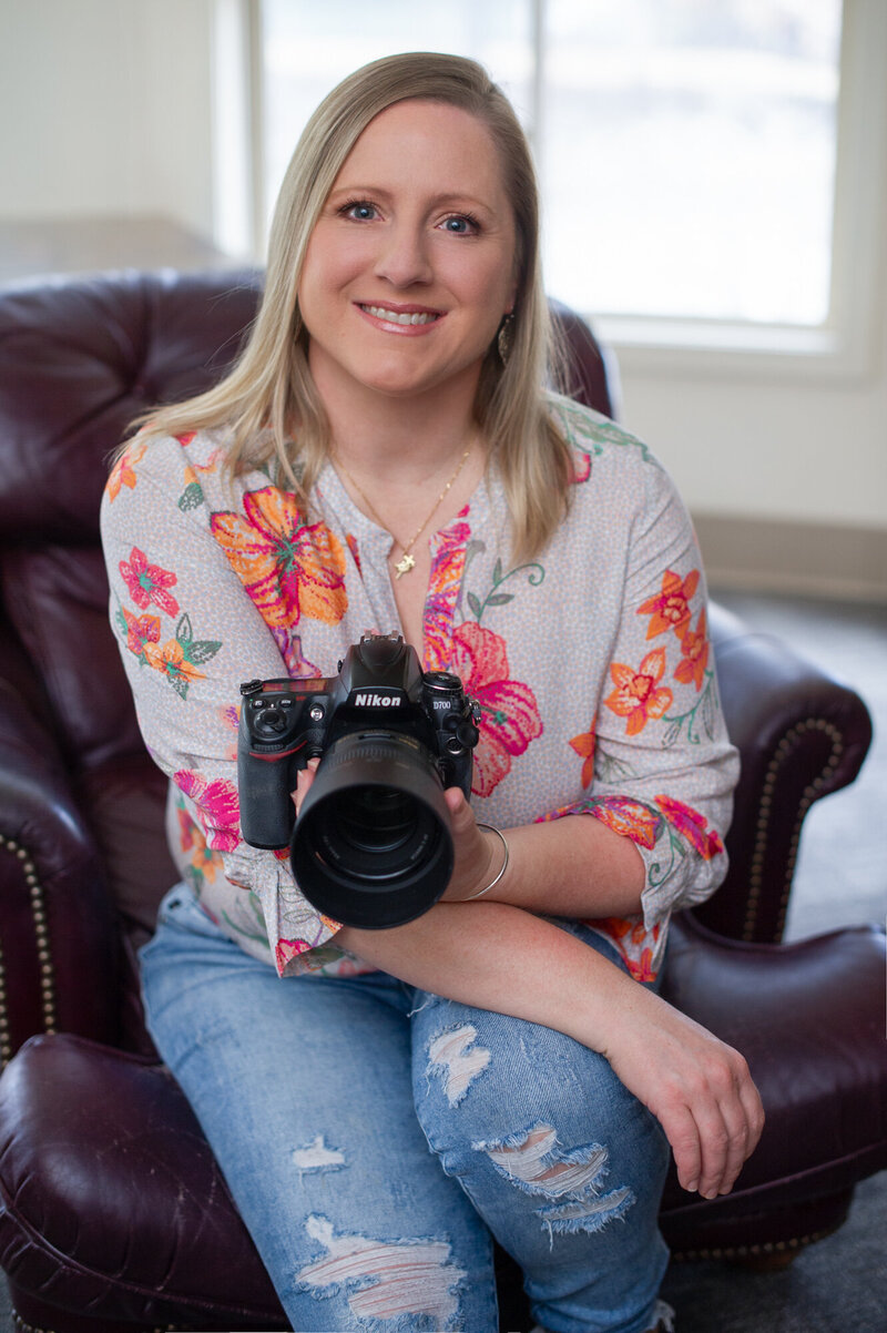 Professional headshot of Boston branding photographer Kristin Palkoner posing with Nikon camera.