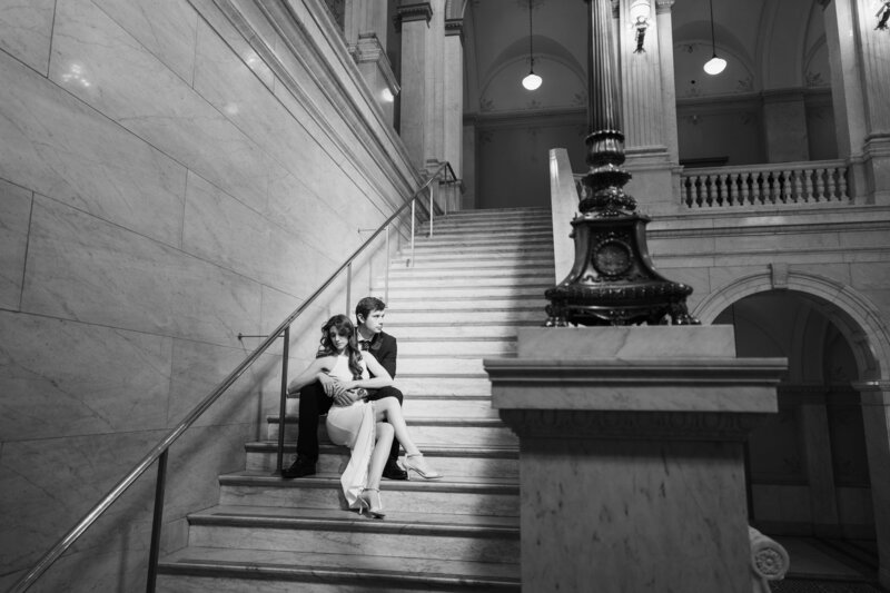 A young couple hold onto each other as they sit on the steps inside the Ohio Statehouse