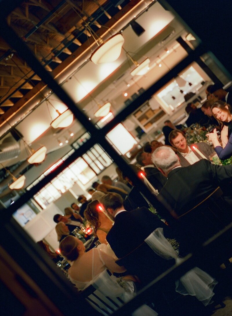 angled shot from outside window into banquet wedding reception by minnesota wedding photographers tom thornton photography