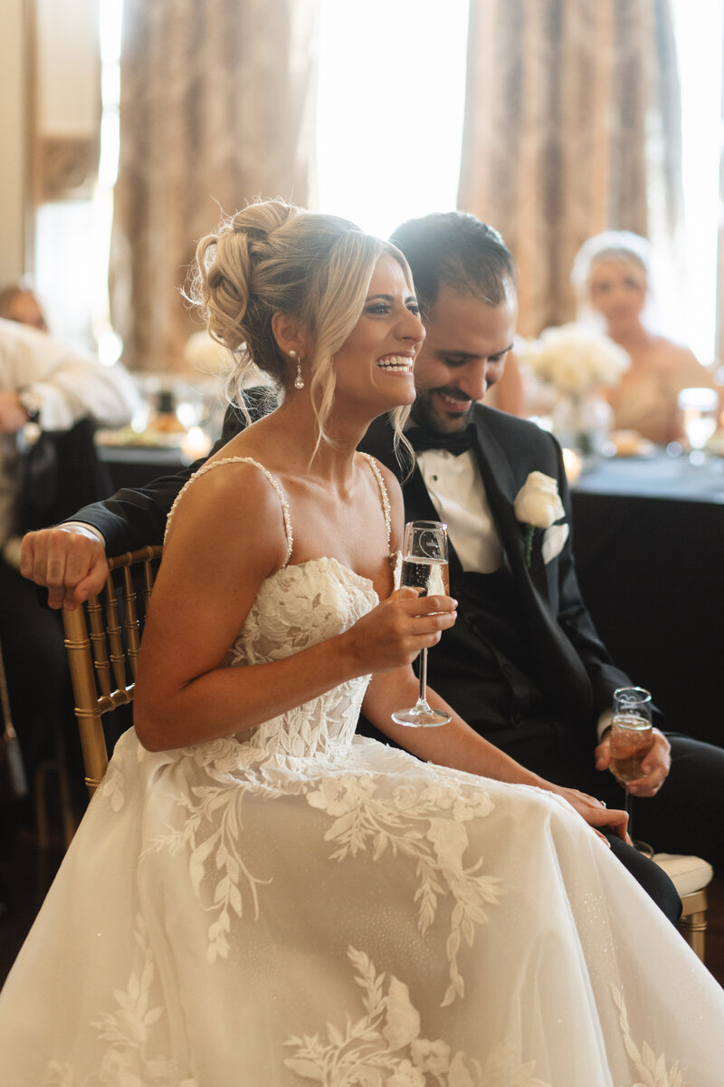 bride and groom during speeches holding champagne 
