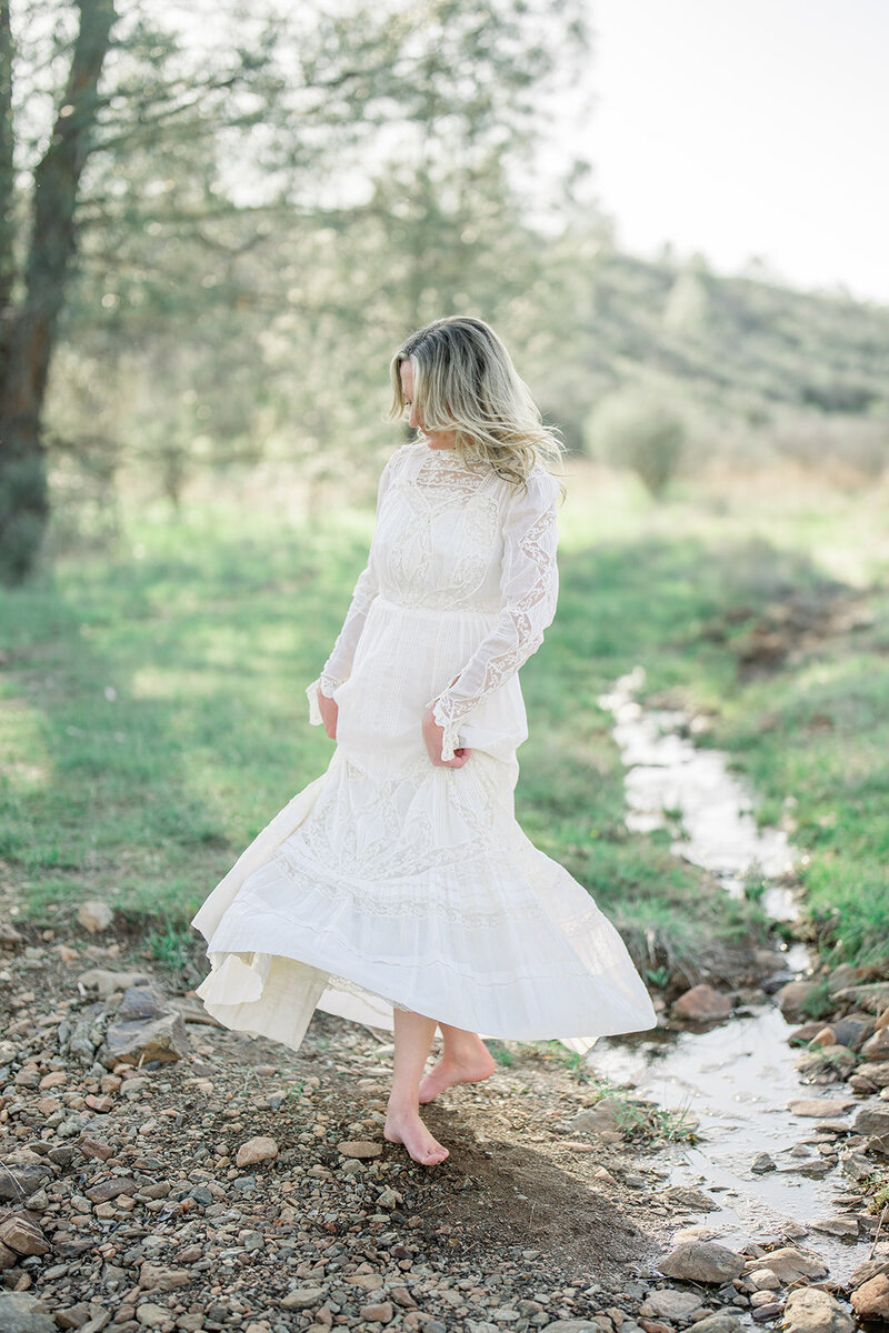 A bride-to-be in a white dress during her engagement session in the lush gardens of Filoli Estate in Woodside, California, captured by Tiffany Longeway Photography.