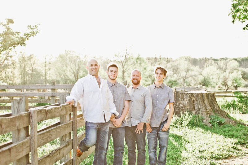 This candid farm portrait captures the easy bond between father and sons in golden light.