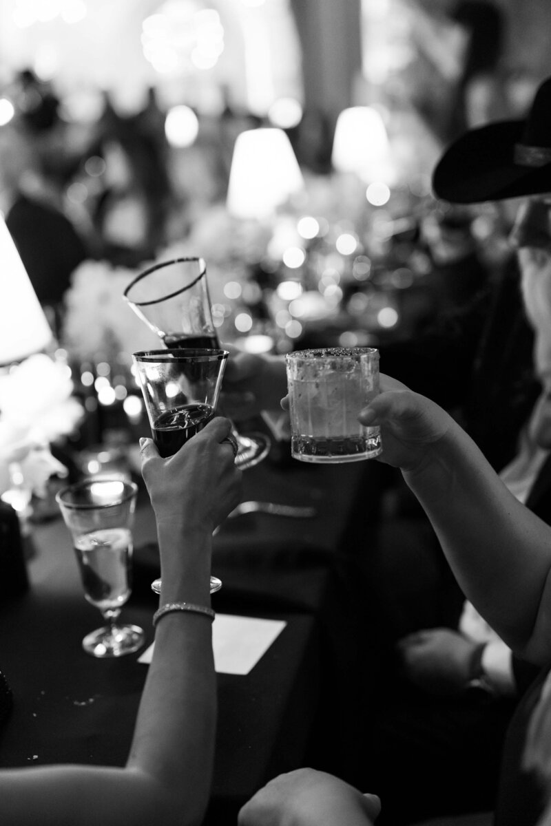 A close up of hands toasting champagne glasses