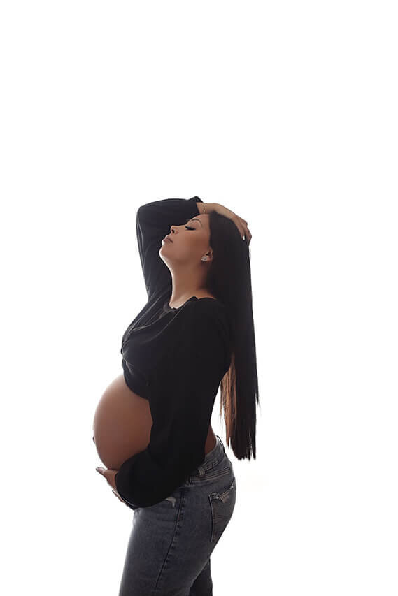 Gorgeous maternity in tight black body suit posing at her luxurious denver studio maternity session.
