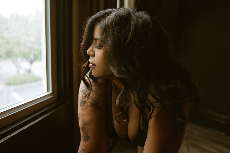 close up of woman with tattoos looking out window