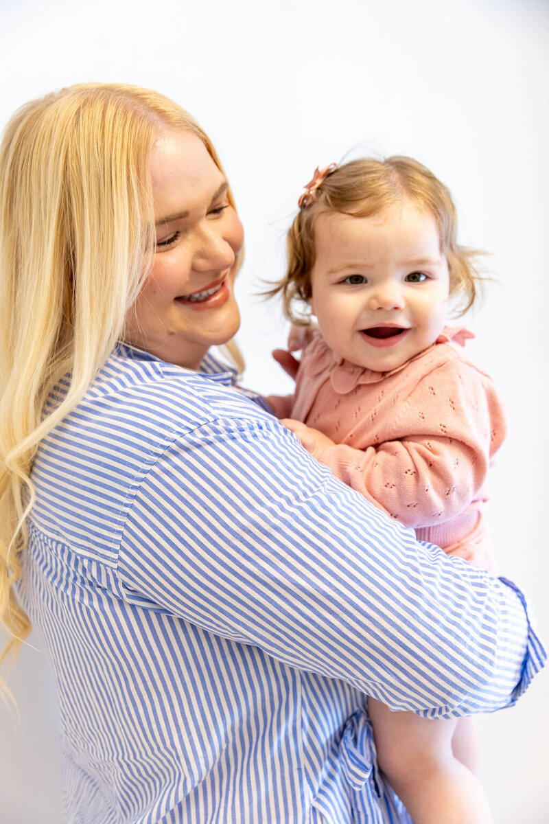 Women smiling as she holds her smiling baby