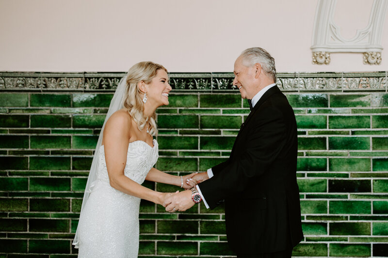 Photo of blonde bride and her father looking at each other happily at Union Station in St. Louis