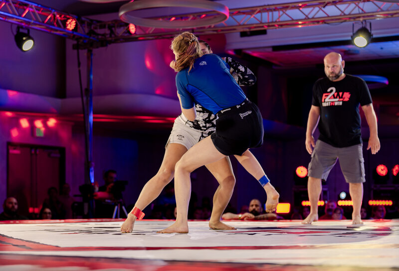 two girls attemping take downs at fight to win