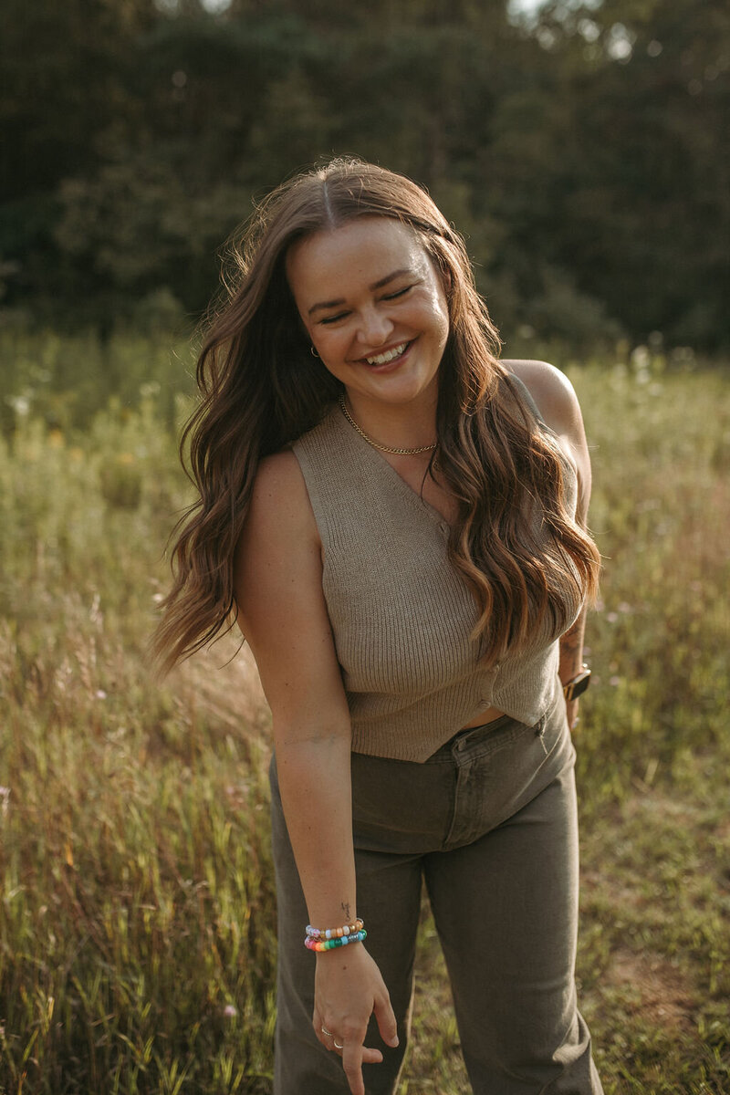 Paige Rini standing in an open field during a personal branding session