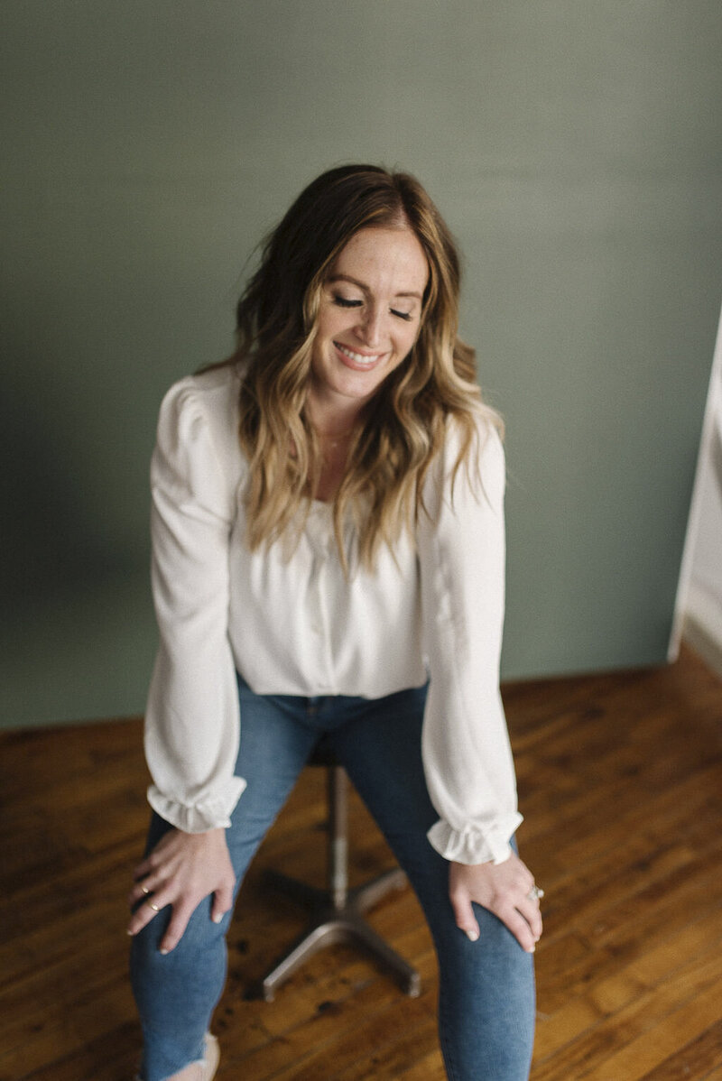 a woman casually dressed sitting on a stool