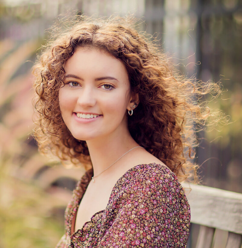 Senior portrait of girl with curly dark hair at Newfields in Indianapolis.