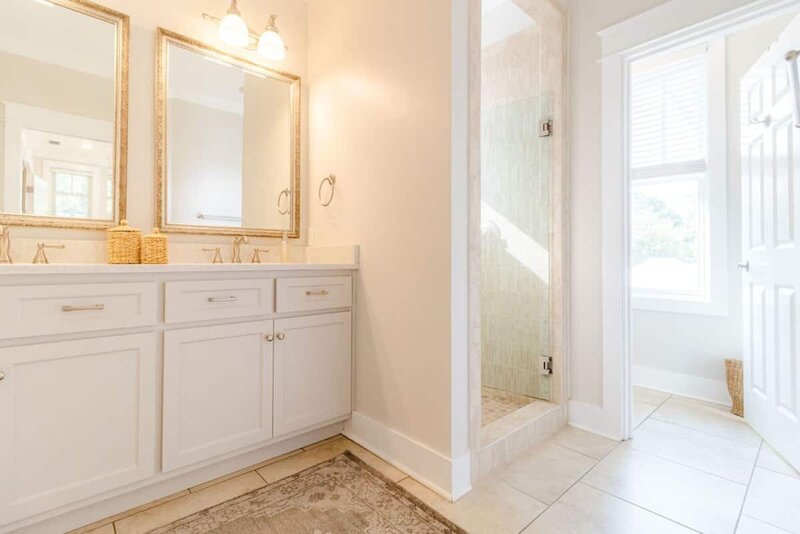 bathroom with walk in shower and double vanity