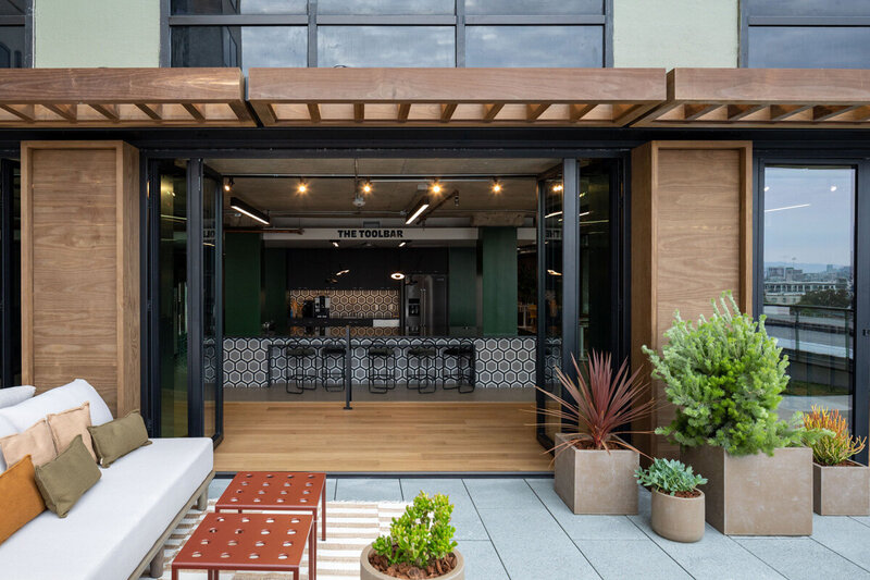 Open-air rooftop bar and lounge named The Toolbar with modern tile design and potted greenery.