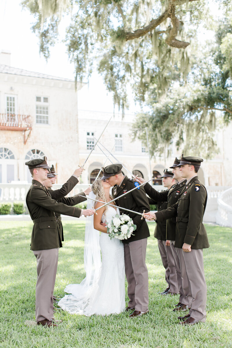 groom in uniform kissing bride
