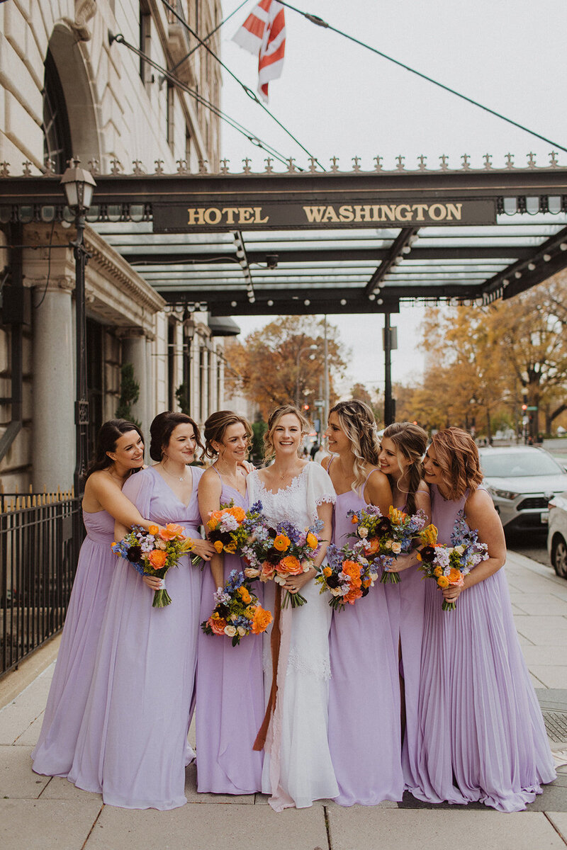 Bridesmaids and bride pose in front of Hotel Washington in DC