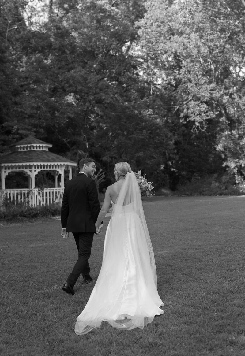 Bride and groom looking at each and smiling while exiting their ceremony