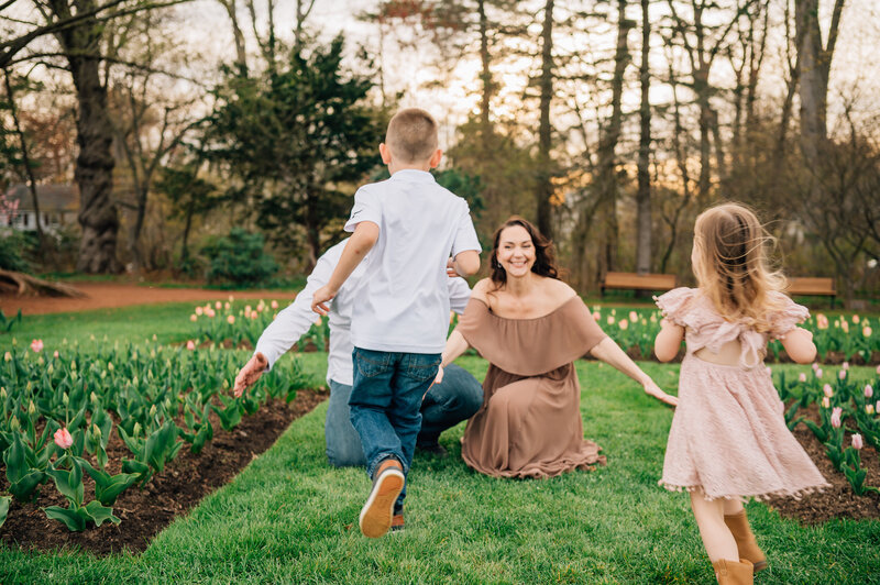 Couple in field, looking down at pregnant mom's belly