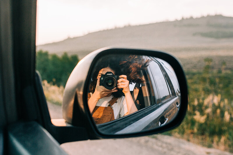 girl taking picture on road trip