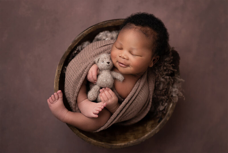 newborn baby boy, swaddle in a brown wrap, smiling