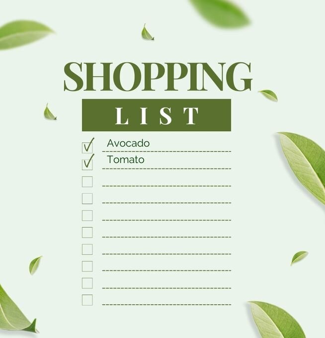 Minimalistic shopping list on a soft green background with checkboxes next to listed items like avocado and tomato, surrounded by scattered green leaves
