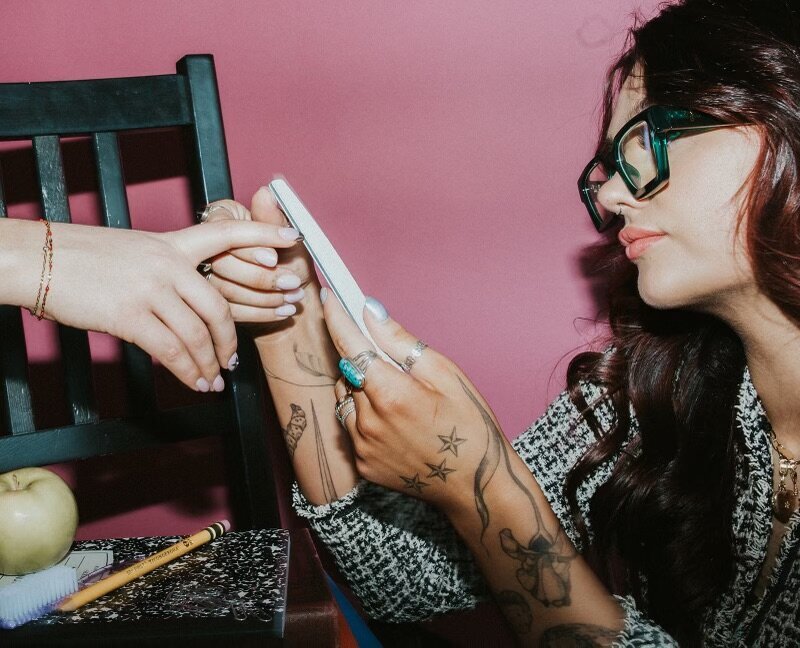 Nail artist using a nail file on a client