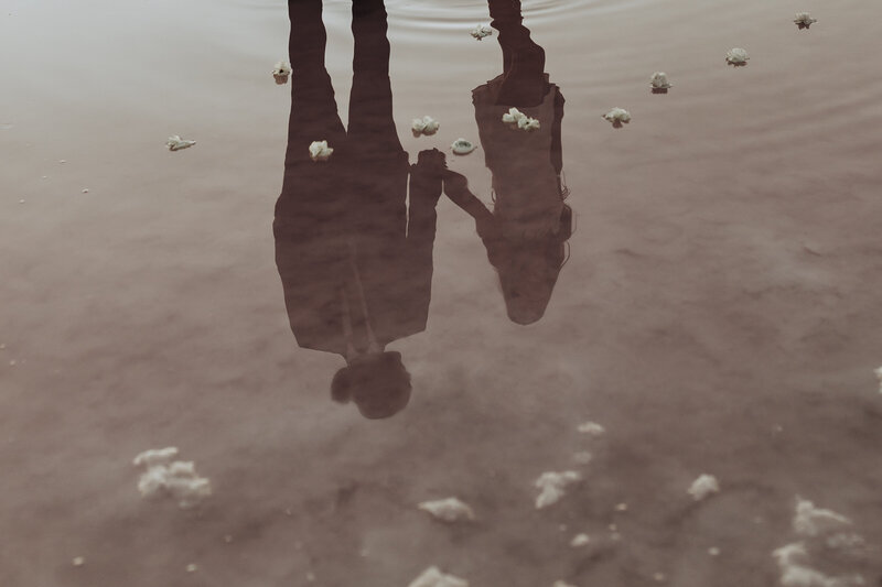 picture of bride and groom in pink water on the salt flats in utah during elopement 