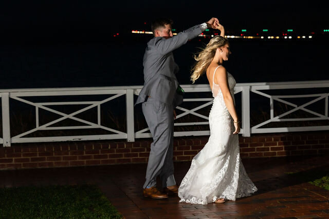 Groom dances with bride at Chesapeake Bay Beachclub, outside at night, Maryland Wedding