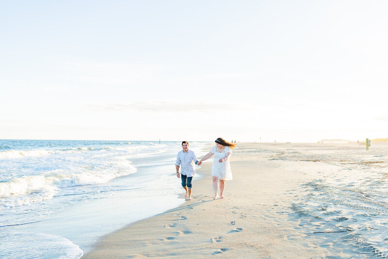 Couple holds hands and dances on North Carolina beach by TMP.